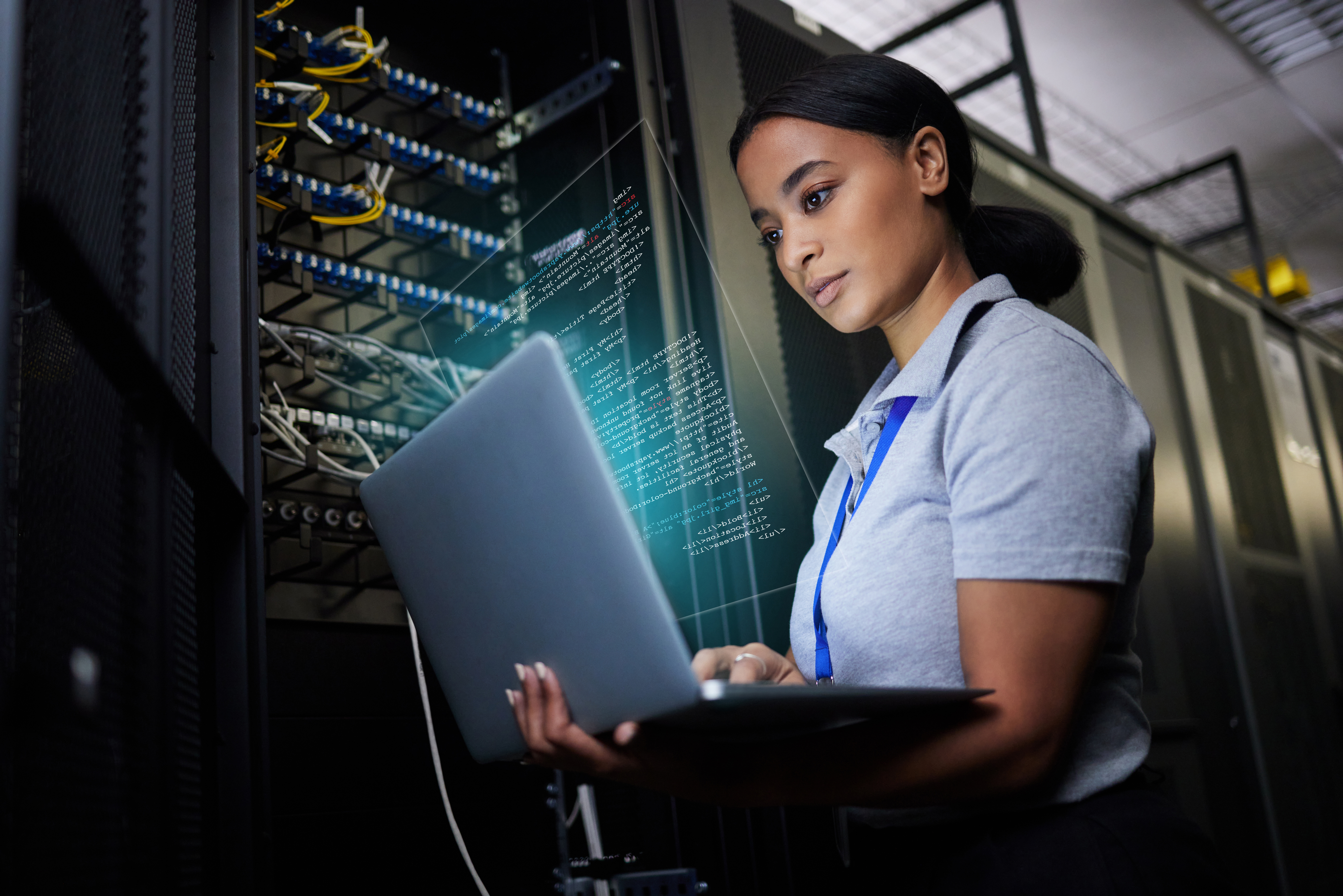 Laptop, network and data center with a black woman it support engineer working in a dark server room. Computer, cybersecurity and analytics with a female programmer problem solving or troubleshooting